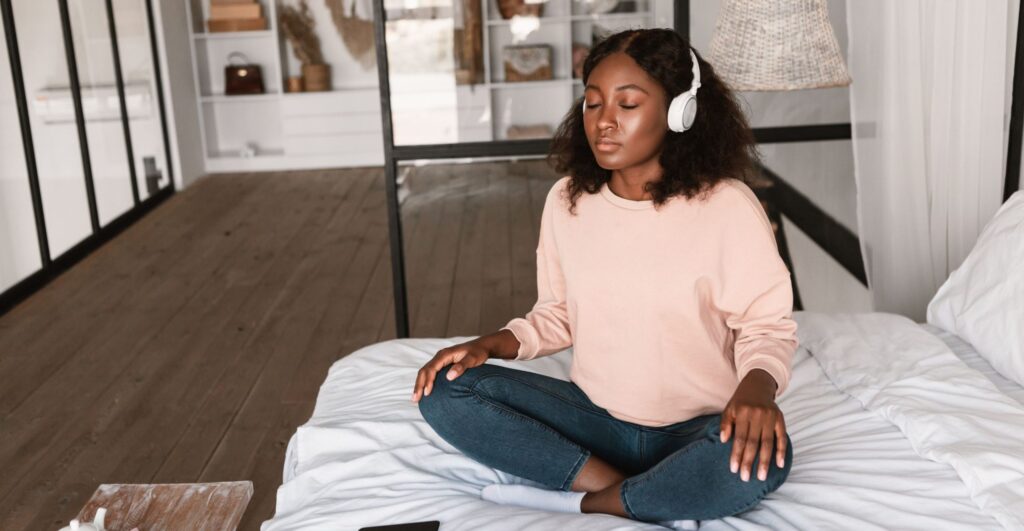 Woman using AI meditation apps with headphones at home